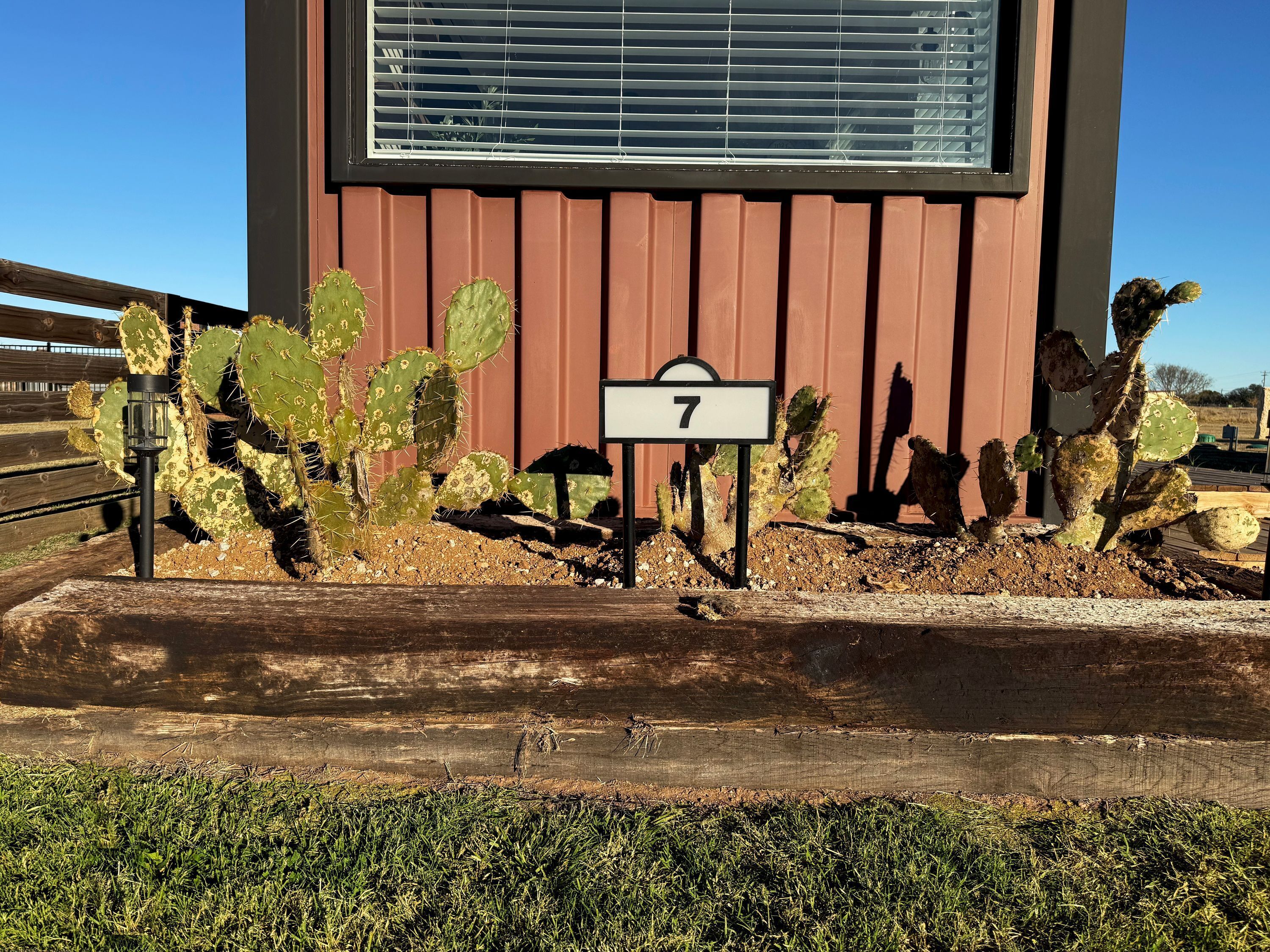 Un bâtiment avec un panneau indiquant le chiffre « 7 » devant un jardin de cactus.