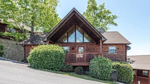 Une cabane en rondins avec un toit triangulaire, une antenne parabolique et un panneau indiquant qu’il s’agit d’un établissement proposant à la fois hébergement et petit-déjeuner.
