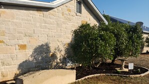 Un bâtiment en pierre avec un toit en pente, un petit arbre et un panneau indiquant un espace de stationnement pour un chalet.