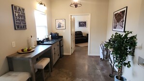 A kitchen with a dining area, a chandelier, and a potted plant. - Unit 1 Chianti Central Tuscan Wine Retreat (Fredericksburg)