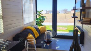 A cozy living room with a sofa, two wine glasses, and a bottle of wine on a table. - Unit 8 Sonoma Depot California Wine Retreat (Fredericksburg)