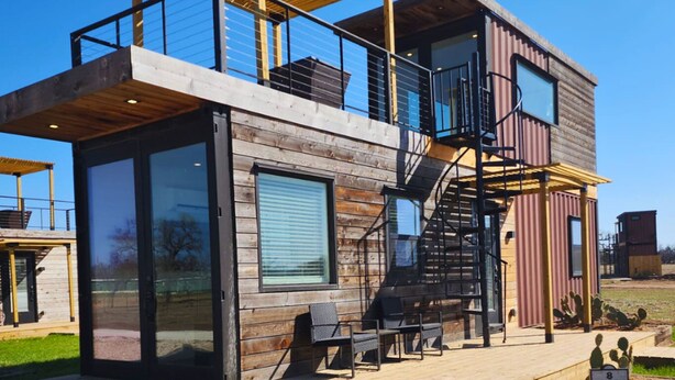 A modern two-story house with a wooden exterior, large windows, and a balcony. - Unit 8 Sonoma Depot California Wine Retreat (Fredericksburg)