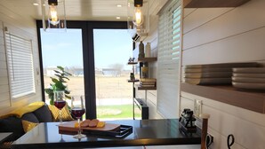 A modern kitchen with a large island, bar stools, and a wine rack. - Unit 8 Sonoma Depot California Wine Retreat (Fredericksburg)