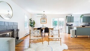 Une cuisine moderne avec un coin repas, un plancher en bois et une cheminée.