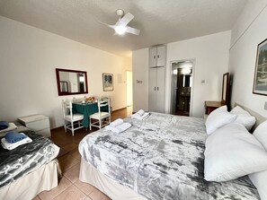A hotel room with a bed, a desk with a chair, a wardrobe, and a bathroom visible through an open door. - 79 AN - Stay Nissi Chrysland Studio 110 (Ayia Napa)