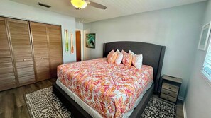 A bedroom with a bed, a nightstand, a wardrobe, and a ceiling fan.