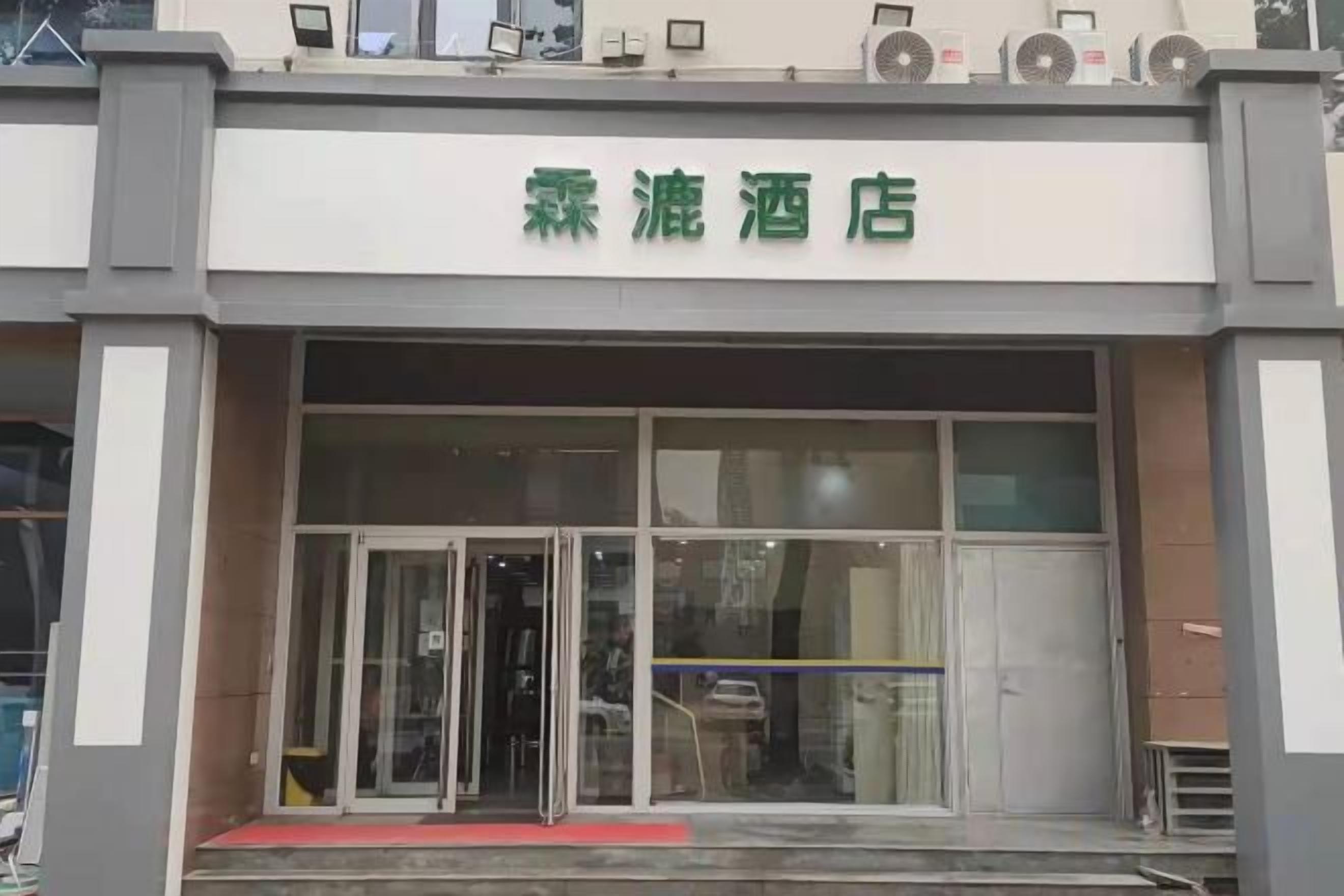 A hotel entrance with a glass door and a red carpet leading up to it.