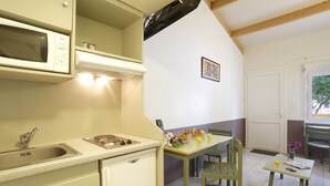 Une cuisine équipée d’un four à micro-ondes, d’un évier et d’un coin repas avec une table et des chaises.