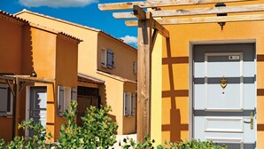 Un edificio amarillo con una puerta blanca y el número 61 en la parte superior.