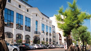 Un immeuble à plusieurs étages, doté de grandes fenêtres et d’une façade blanche.