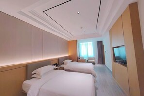 A hotel room with two beds, a TV, and a view of the city. - XinzhuXuan Hotel (Haikou Longhu Tianshi Park Shop) (Haikou)