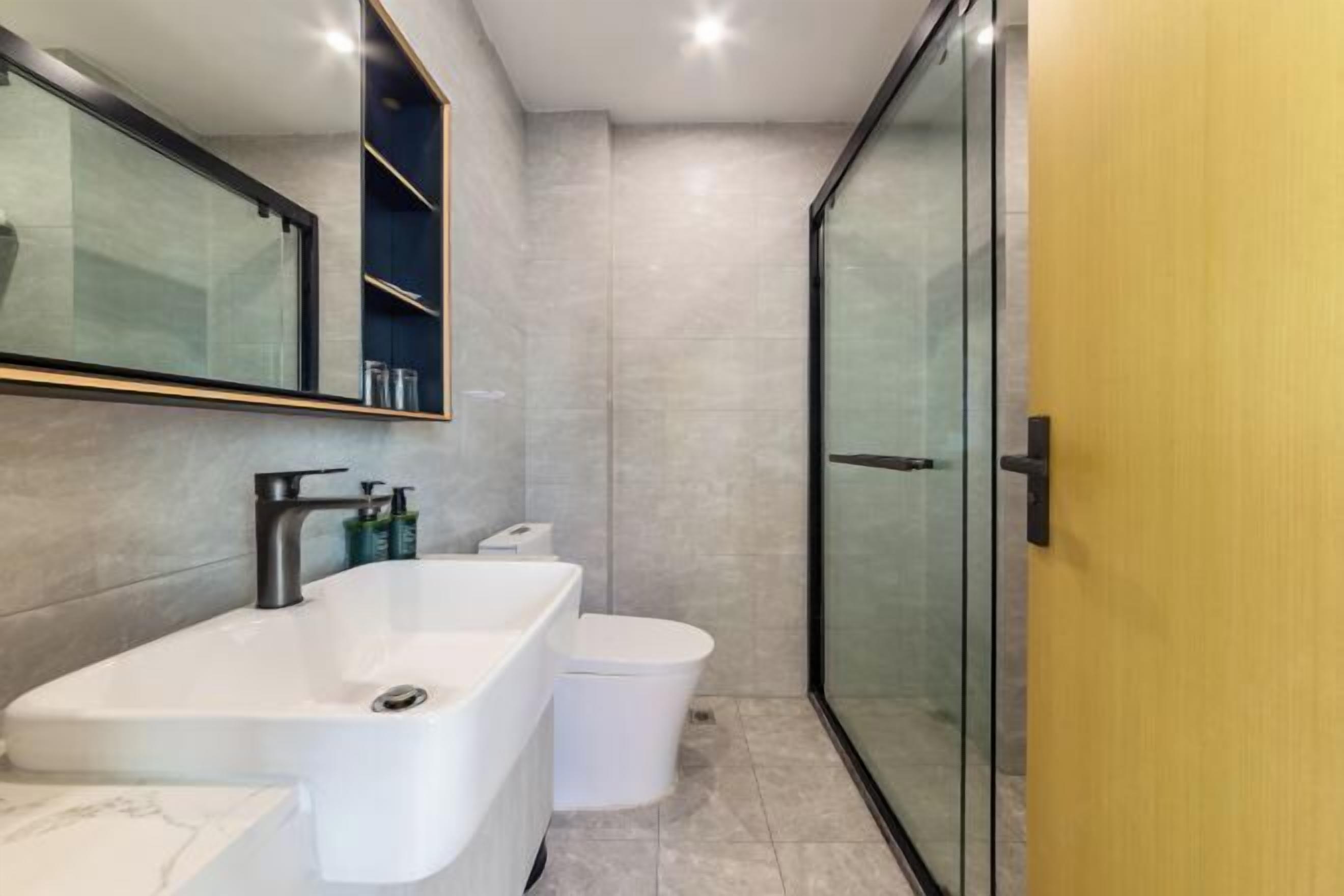 Un baño moderno con una bañera grande, un inodoro y una cabina de ducha de vidrio.