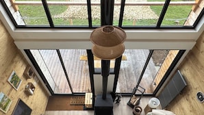 Una habitación amplia con un tragaluz grande, chimenea, sofá y zona de comedor.