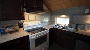 A kitchen with dark wooden cabinets, a white stove, and a granite countertop.