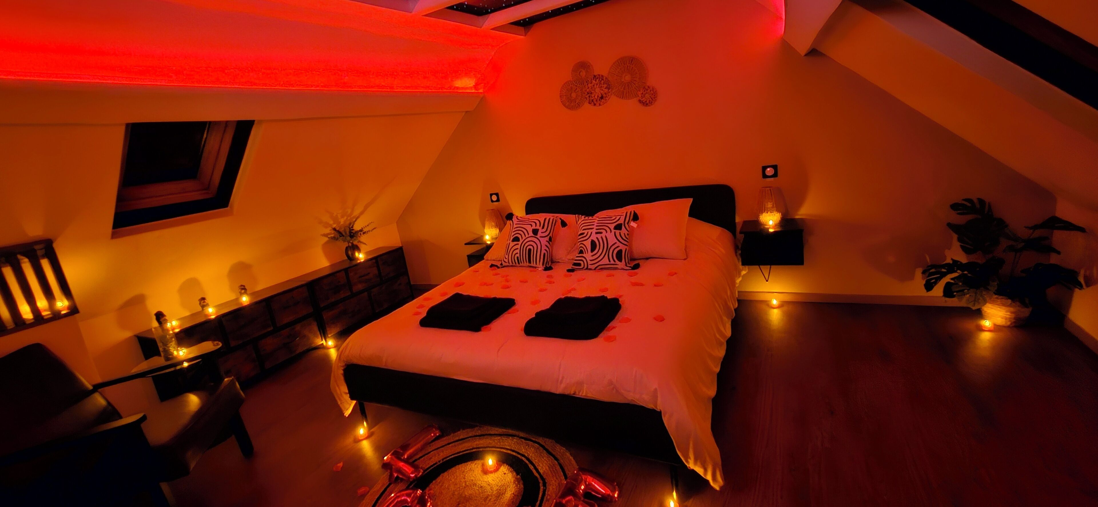 Een slaapkamer met een bed, nachtkastjes, een stoel en een tafeltje met decoratieve objecten.
