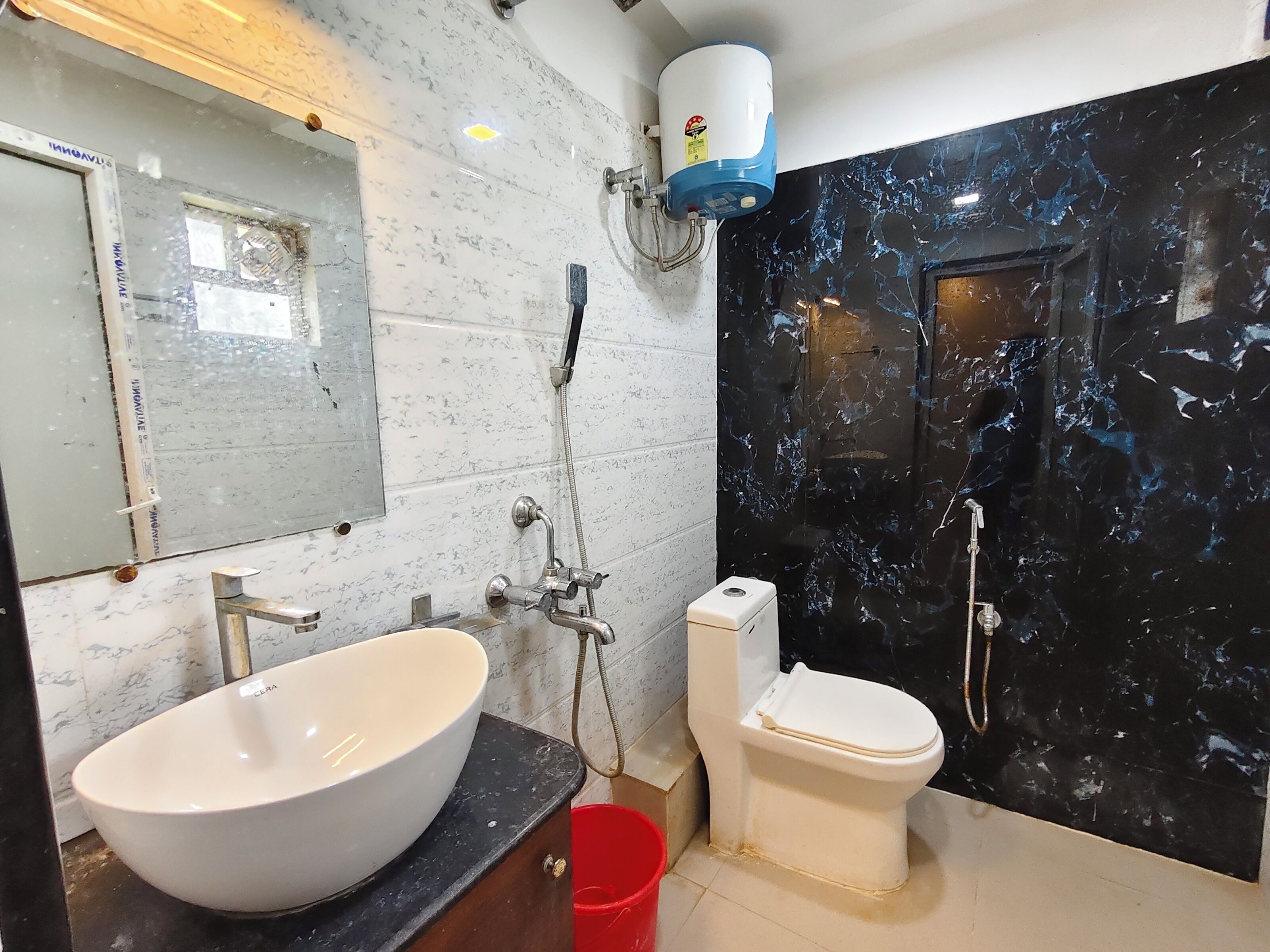 A bathroom with a large white basin, a toilet, and a shower area.
