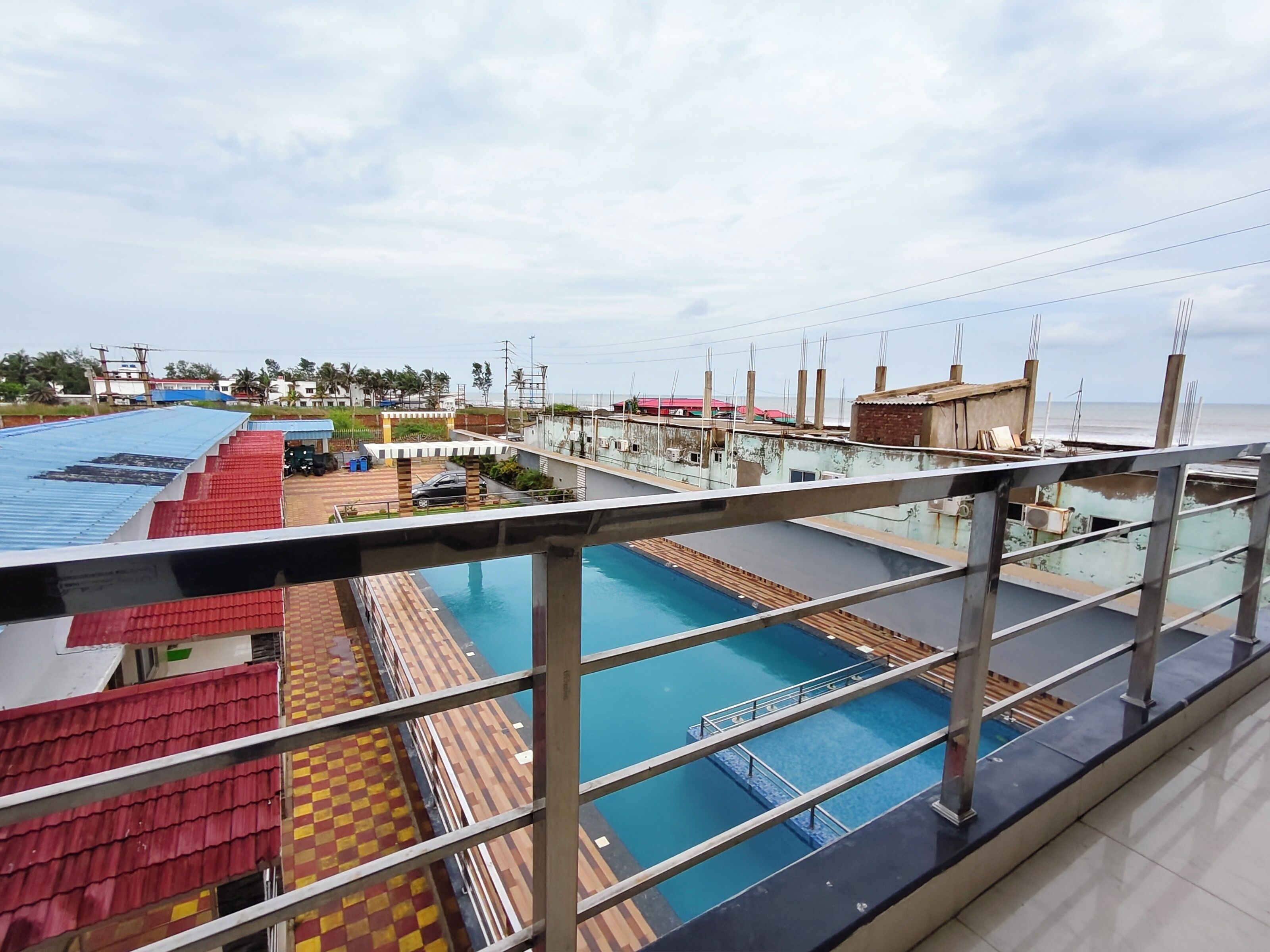 A pool area with a clear view of the surrounding buildings and a distant shoreline.