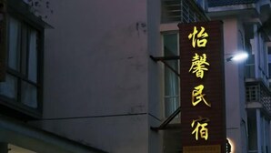 A building with a vertical sign displaying Chinese characters. - Yixin Homestay (Wuyishan)