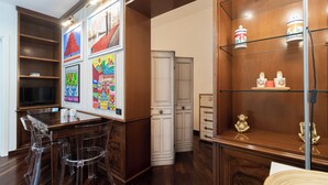 A room with a wooden desk, clear chairs, a television, and artwork on the walls. - Italianway Easy - Garibaldi 49 (Milano)