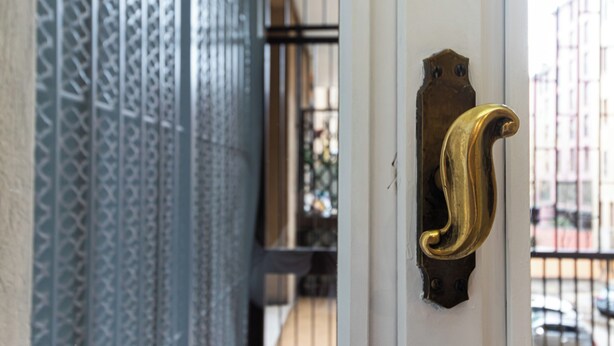 A door with a brass handle and a patterned metal grille. - Italianway Easy - Garibaldi 49 (Milano)