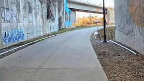 A concrete pathway under a bridge with graffiti on the walls and a street lamp on the right. - Historic Cabbagetown by  Stadium, walk to Eastside BeltLine, Krog St. Market (Atlanta)