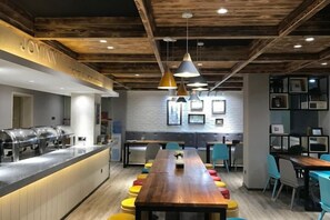 A modern kitchen area with a long counter, bar-style seating, and pendant lighting. - Yayue Exquisite Hotel (Zhengzhou Erqi Square David City Branch) (Zhengzhou)