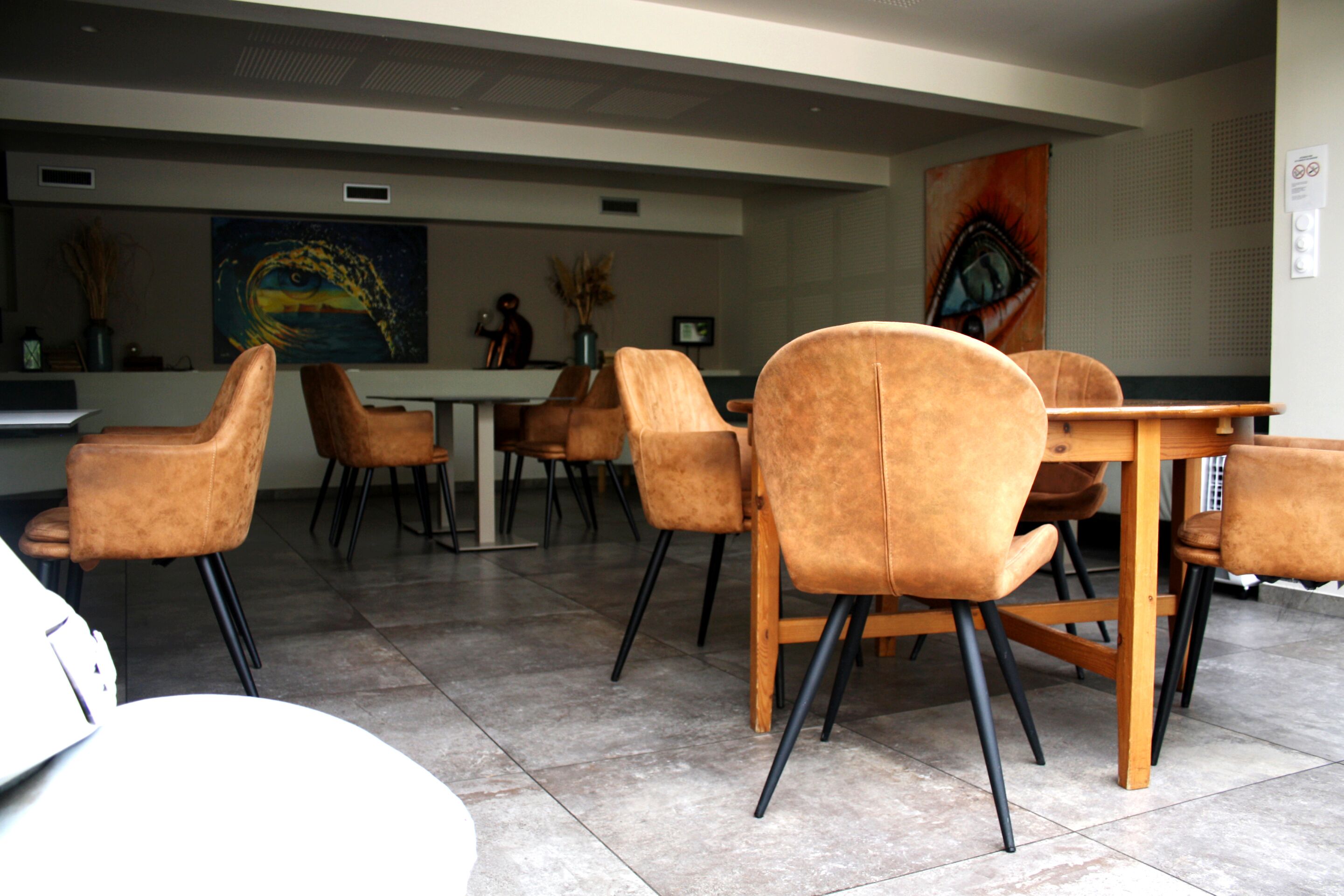 A modern dining area with brown upholstered chairs and a wooden table.