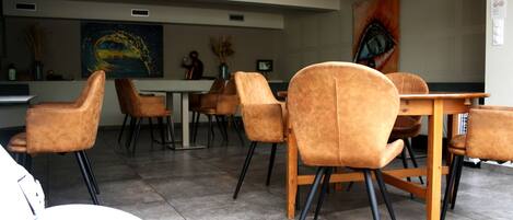 A modern dining area with brown upholstered chairs and a wooden table.