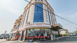 Un immeuble à plusieurs étages doté d’une façade incurvée, de grandes fenêtres et d’une enseigne indiquant qu’il s’agit d’un hôtel.