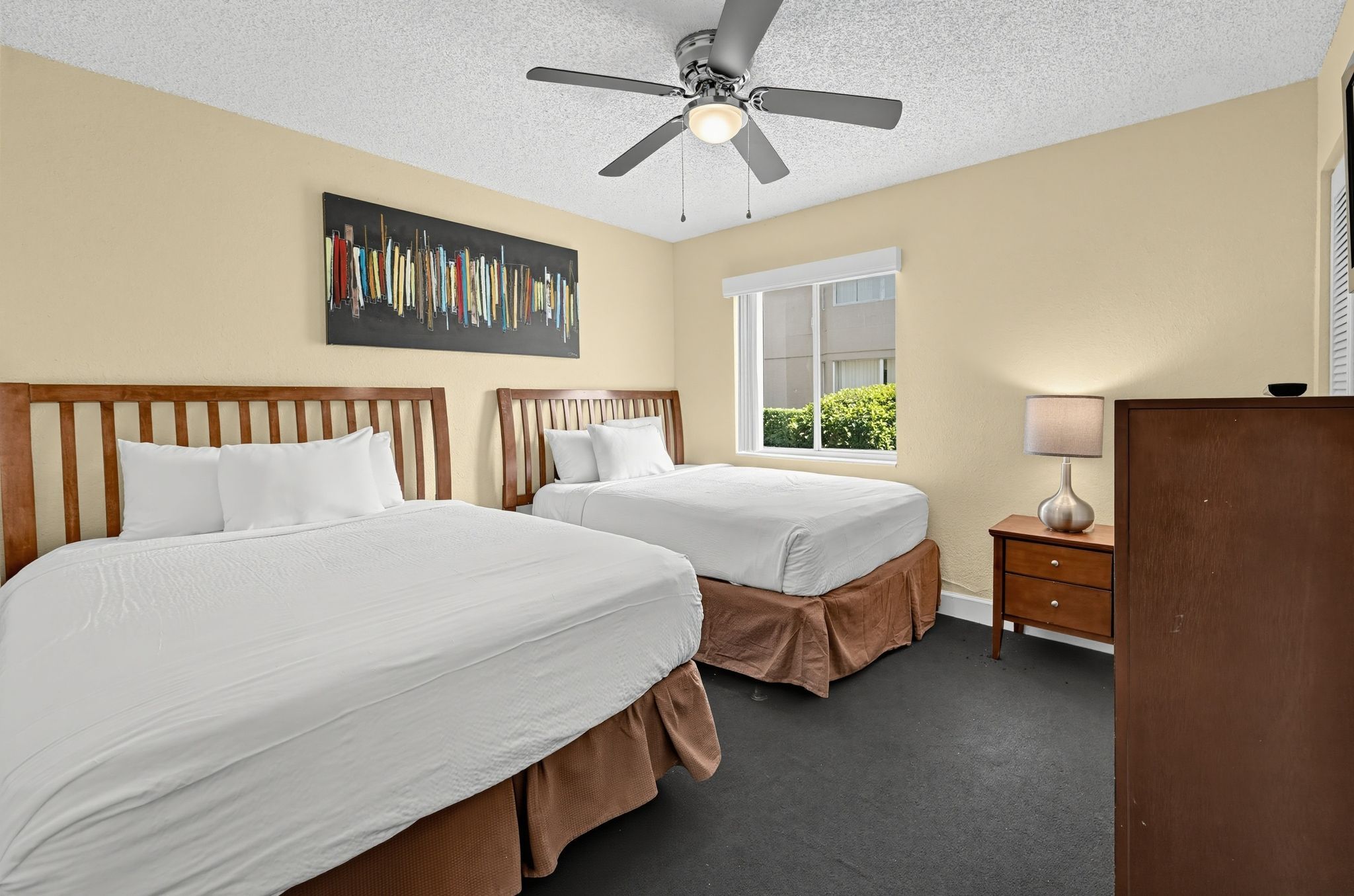 Bedroom with two beds, a ceiling fan, and a breezy, relaxed feel