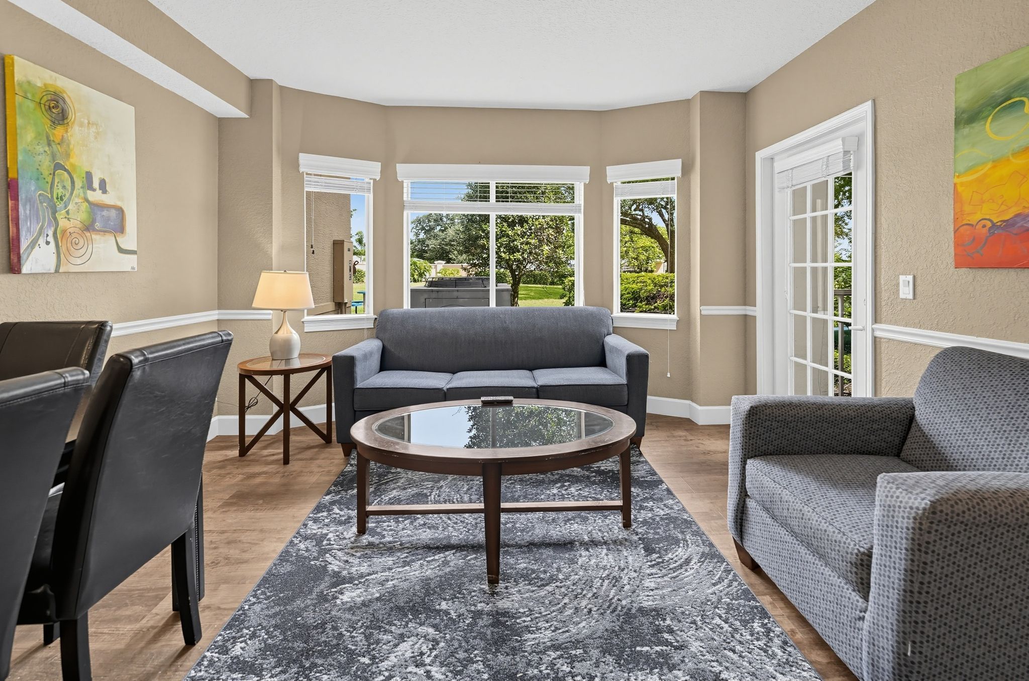 A living room with a gray sofa, a coffee table, and a patterned rug.