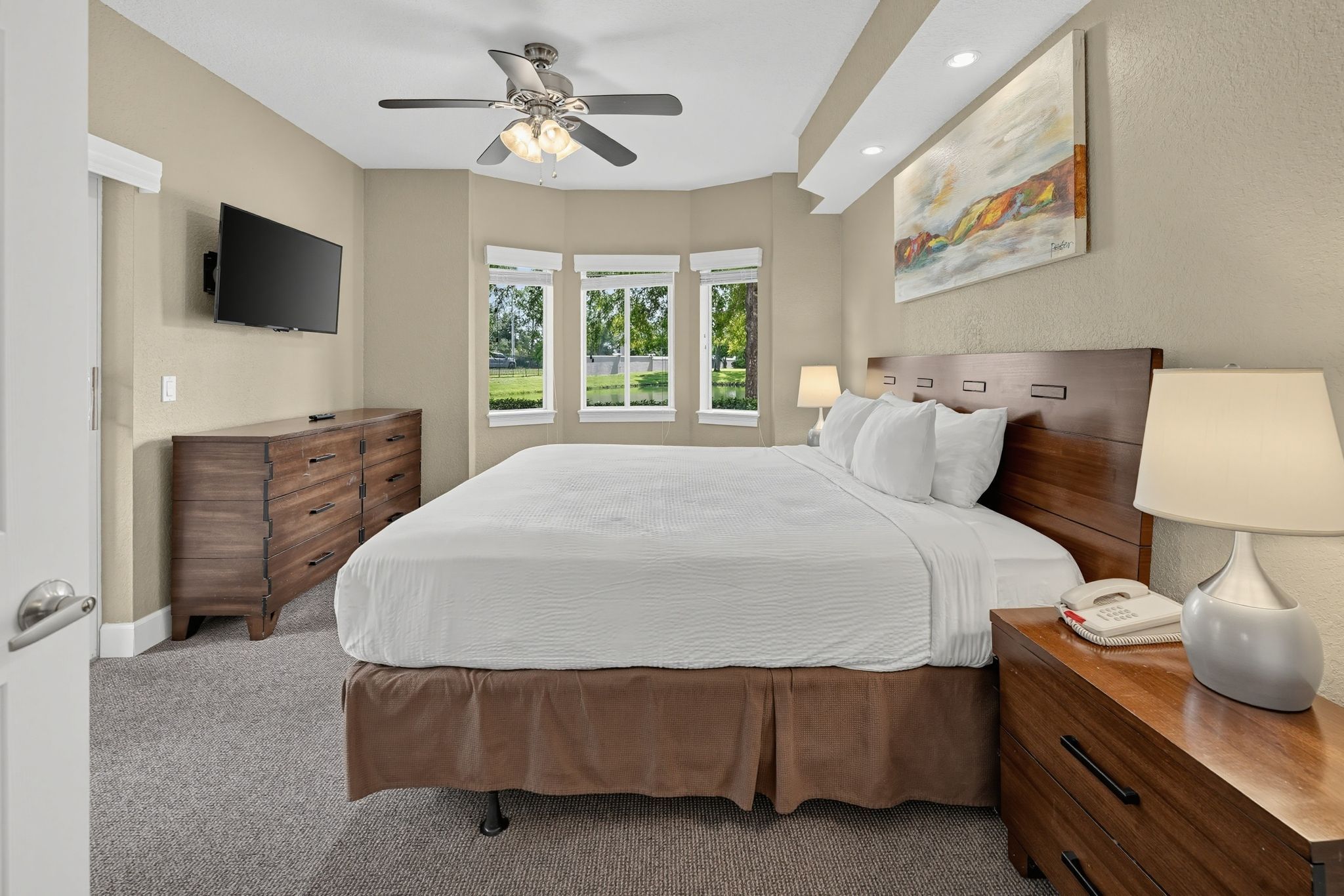 Sunlit room with large bay windows and soft, neutral furnishings