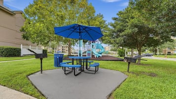 Shaded picnic area with blue seating and tables for outdoor dining