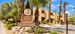 Entrance sign surrounded by palm trees and flower beds - Accessible 2BR Condo w/ Shared Pool (Palm Springs)