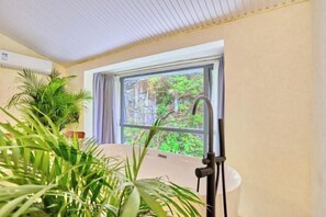 A room with a large window, a ceiling fan, and potted plants. - Yishan Xiaozhu (Yangshuo West Street store) (Yangshuo)