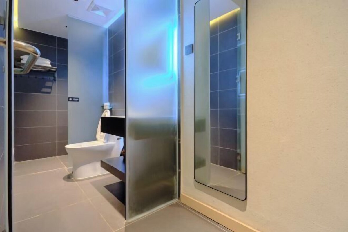 A modern bathroom with a toilet, a glass partition, and a shower area.