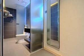 A modern bathroom with a toilet, a glass partition, and a shower area. - Yishan Xiaozhu (Yangshuo West Street store) (Yangshuo)