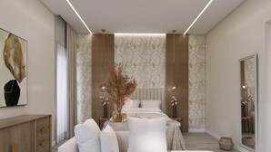 A modern bedroom with a large bed, a sofa, and a nightstand. - Ripetta Grand Suites (Rome)