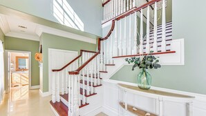 A grand staircase with white balusters and wooden steps, leading to an upper floor. - 5 Mi to Beach: Spacious Home on Hilton Head Island (Hilton Head Island)