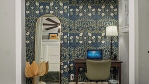 A room with a desk, chair, lamp, and a mirror reflecting a door. - CozyVibeStay . King Bed. Parking. Walk to Beach (Long Beach)