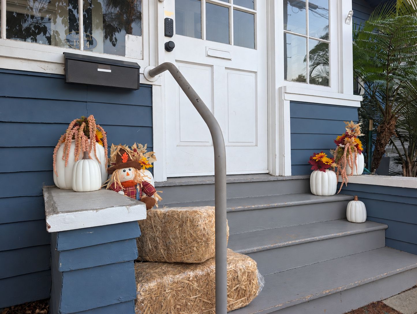 A front porch with a mailbox, a door, and steps leading to the entrance.