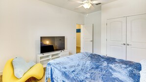 A bedroom with a bed, a TV, a ceiling fan, and a wardrobe. - 7 Mi to Flagler Beach: Breezy Stay w/ Pool Access! (Palm Coast)
