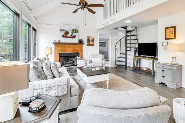 A spacious living room with a fireplace, a television, and a staircase leading to an upper level. - Lake & Golf Course Views: Big Canoe Home w/ Deck! (Jasper)
