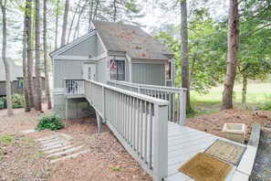 A small wooden cabin with a porch and a flag, surrounded by trees. - Lake & Golf Course Views: Big Canoe Home w/ Deck! (Jasper)