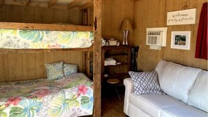 A cozy cabin with a bunk bed, a sofa, and a small table. - Pop's Place on the Rapidan River. (Rochelle)