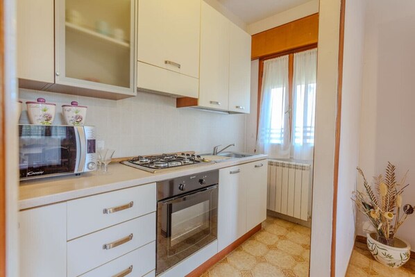 Oven, coffee/tea maker, cookware/dishes/utensils, dining tables