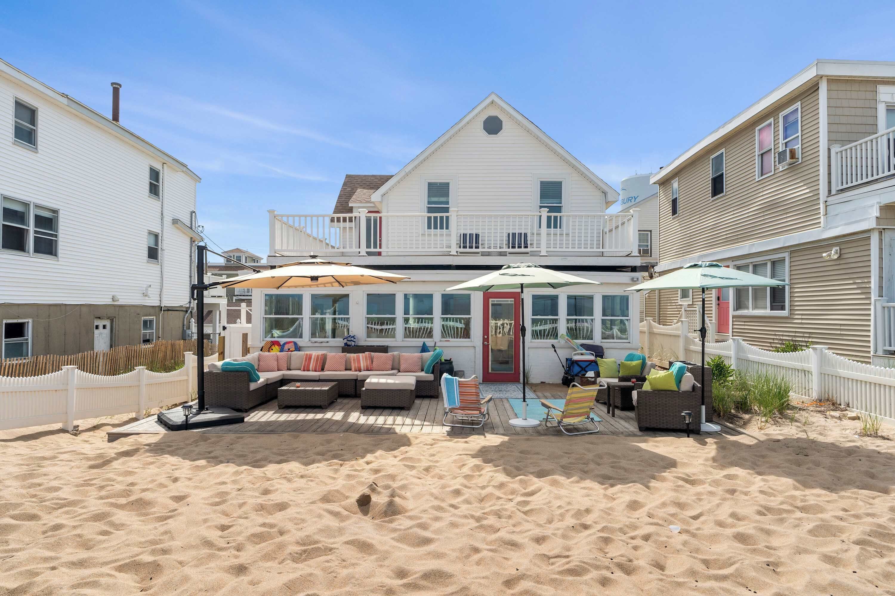 A beachfront property with a covered patio, outdoor seating, and a pool.