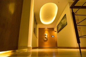 A hotel hallway with a wooden door marked '3', a ceiling light, and a framed picture on the wall. - Xiangru Chain Hotel (Shanghai Caogen (Shanghai)