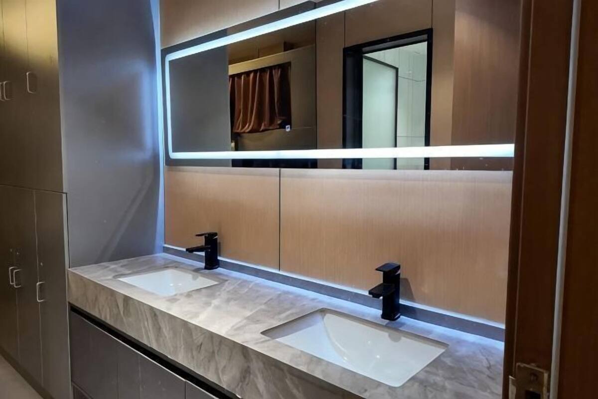 A bathroom with two sinks, a mirror, and a towel rack.