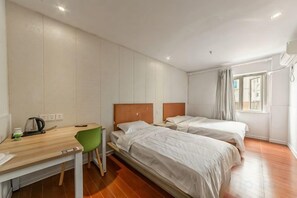A hotel room with two beds, a desk, a chair, and a window with curtains. - Xiangru Chain Hotel (Shanghai Caogen (Shanghai)